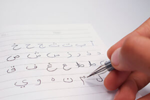 Student practising Egyptian Arabic handwriting in a class at Marhaba Arabic School Luxor